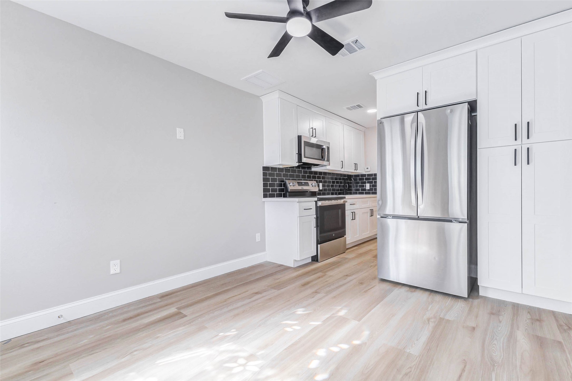 1054 Dewalt Street Houston, TX 77088 - Photo 6 of 24 a kitchen with white cabinets and stainless steel appliances