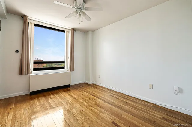 a view of a hallway with wooden floor and a window