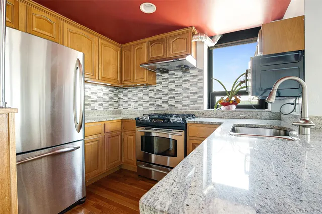 a kitchen with stainless steel appliances granite countertop a sink and cabinets