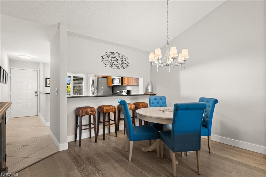 3012 Sandpiper Bay Circle, Unit D302 Naples, FL 34112 - Photo 3 of 16 a view of a dining room with furniture and chandelier
