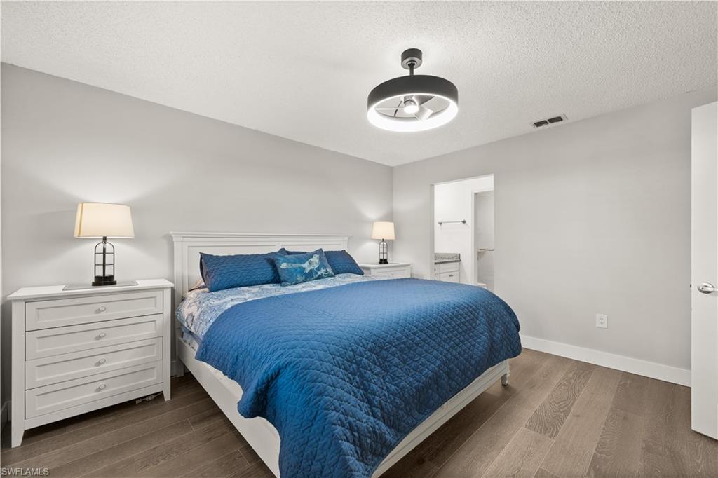 3012 Sandpiper Bay Circle, Unit D302 Naples, FL 34112 - Photo 7 of 16 a bedroom with a bed and cabinet