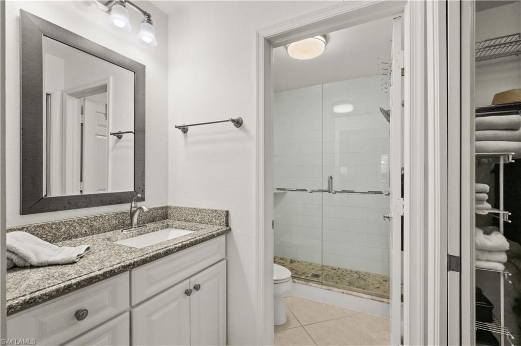 3012 Sandpiper Bay Circle, Unit D302 Naples, FL 34112 - Photo 8 of 16 a bathroom with a granite countertop sink two mirror and shower