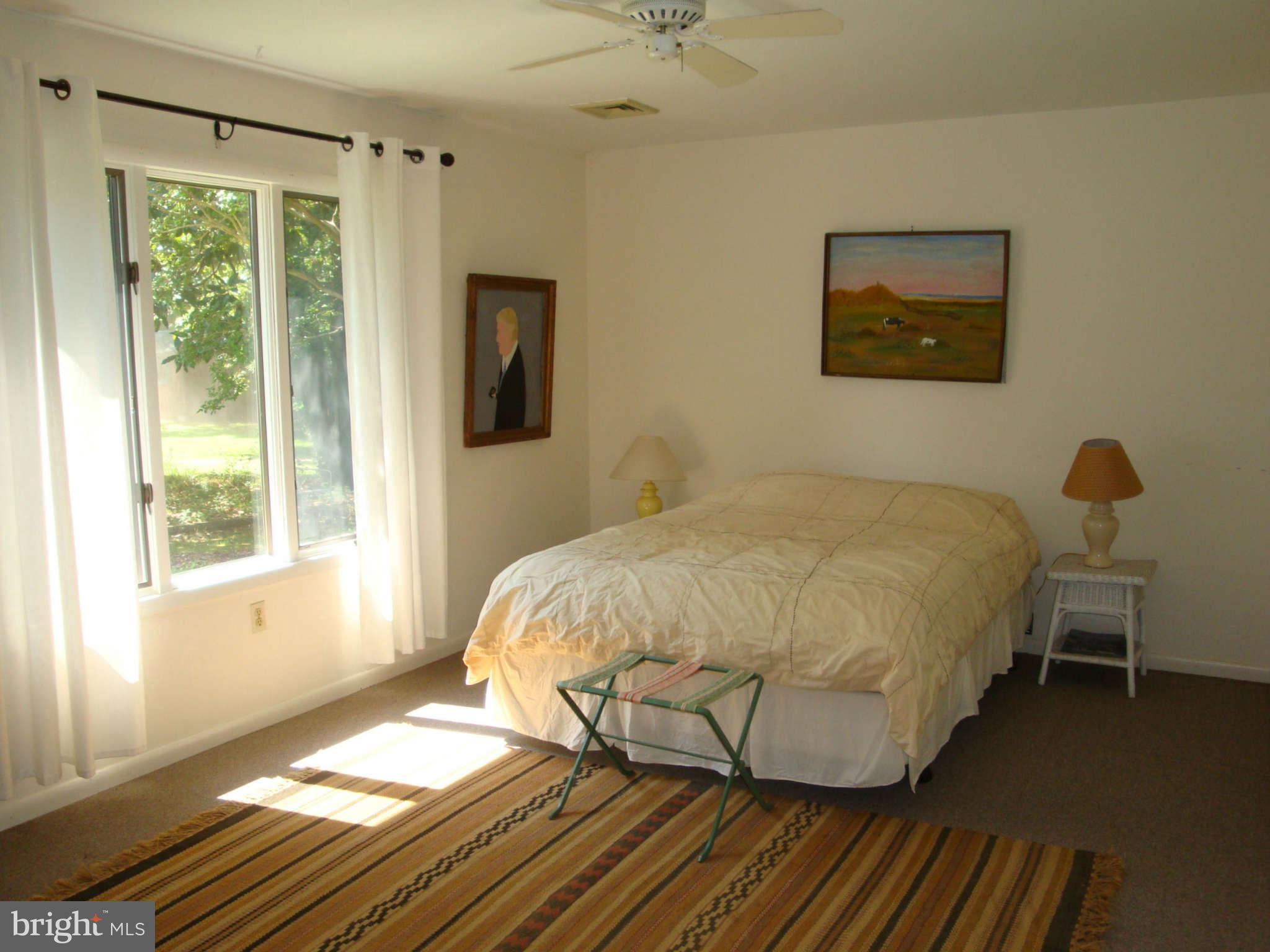 48868 Curleys Road Ridge, MD 20680 - Photo 22 of 30 a bedroom with a bed and wooden floor