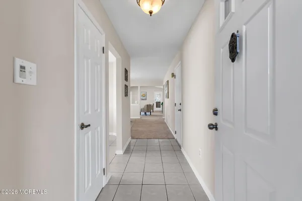 a view of a hallway with a livingroom and a bathroom with sink