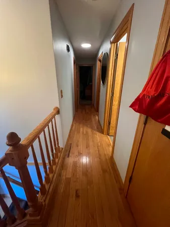 a view of a hallway with wooden floor and stairs
