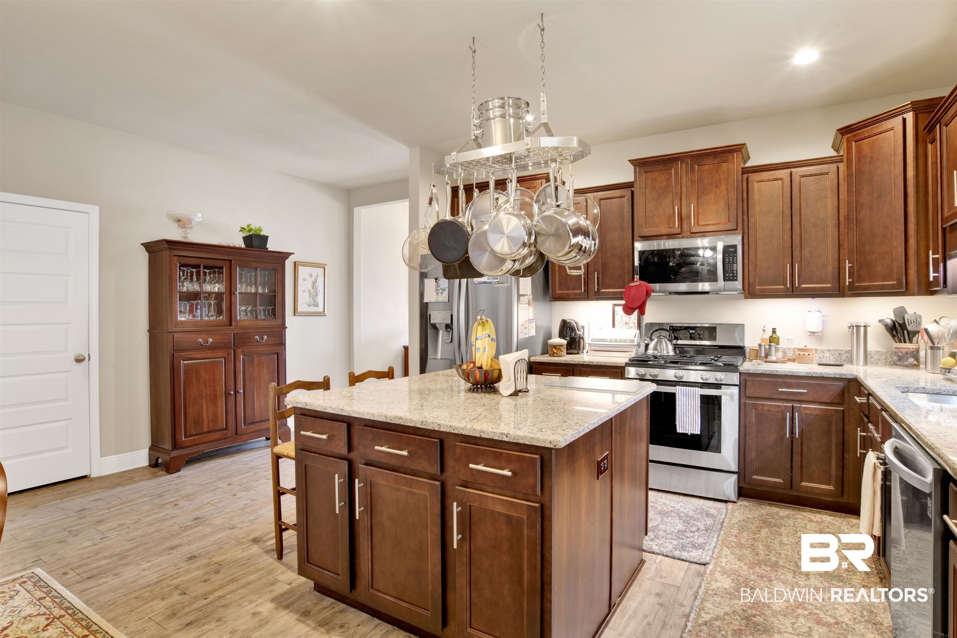 1476 Surrey Loop Foley, AL 36535 - Photo 11 of 31 Kitchen featuring a breakfast bar, stainless steel appliances, a center island, light stone countertops, and light wood-type flooring