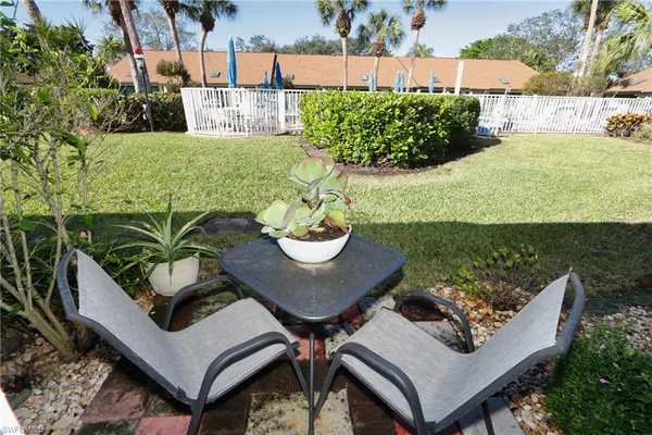 a view of a patio with table and chairs potted plants