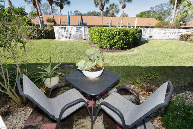 a view of a patio with table and chairs potted plants