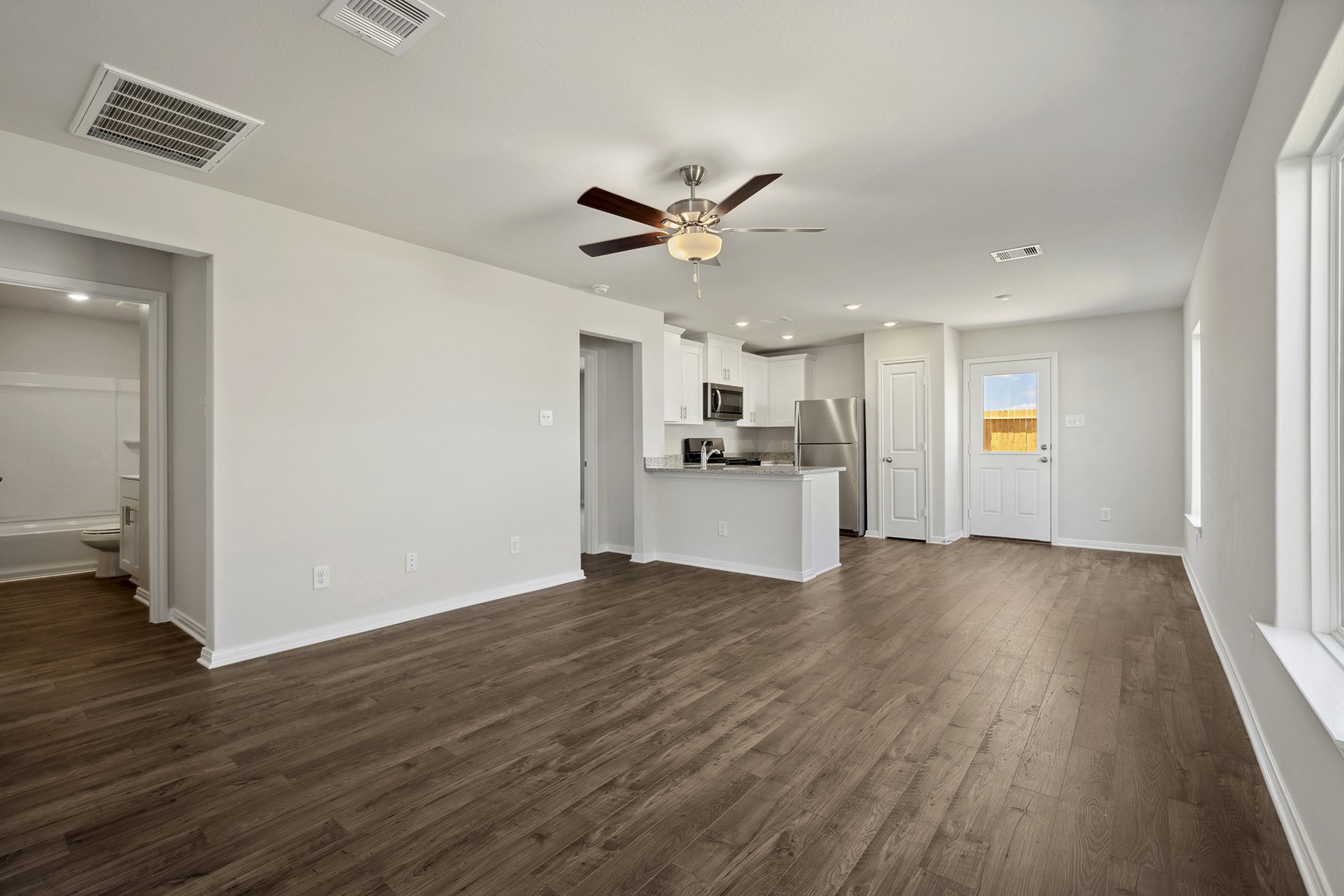 10402 Red Cardinal Drive Cleveland, TX 77328 - Photo 5 of 24 wooden floor in an empty room with a kitchen
