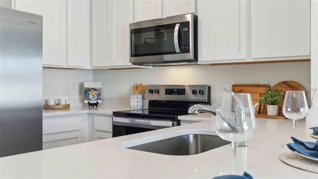 a kitchen with stainless steel appliances granite countertop a sink and a stove top oven