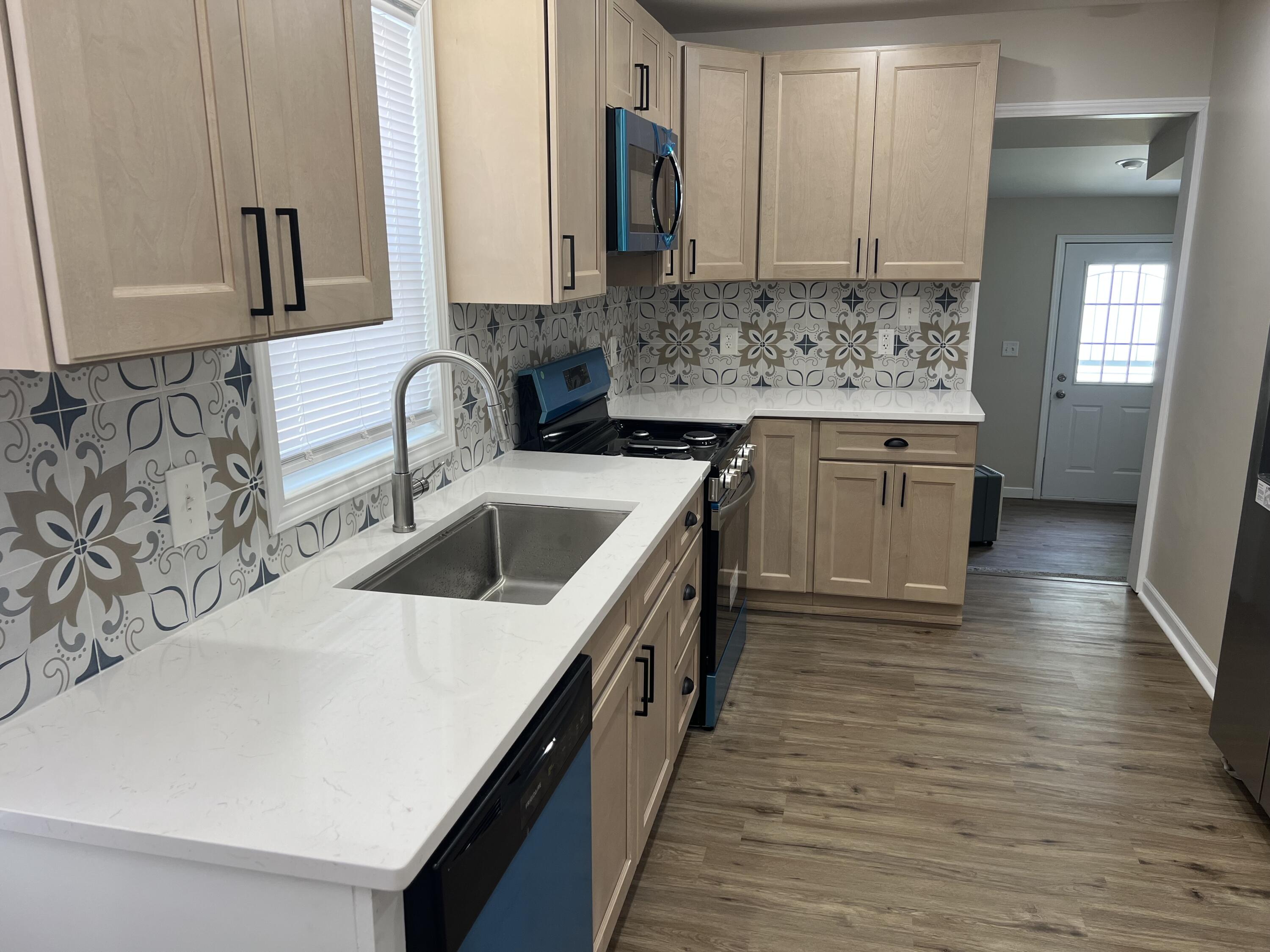 3851 Maple Street Hobart, IN 46342 - Photo 13 of 28 a kitchen with a sink stove and cabinets