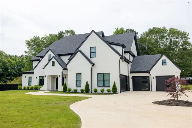 a front view of a house with a garden and yard