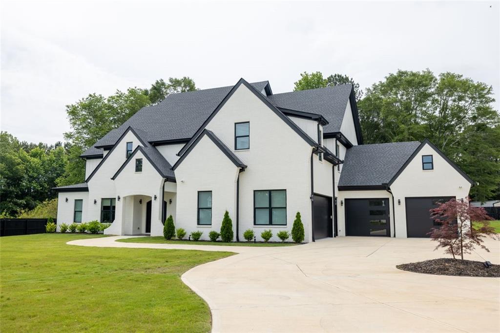 a front view of a house with a garden and yard