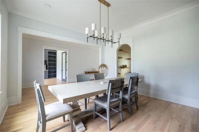a view of a dining room with furniture a chandelier and wooden floor