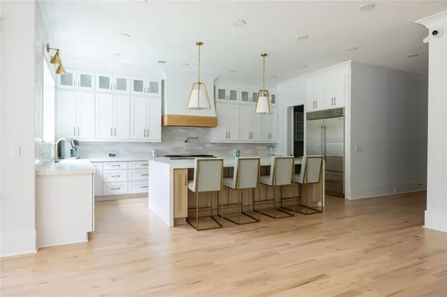 a kitchen with stainless steel appliances kitchen island granite countertop a refrigerator and cabinets