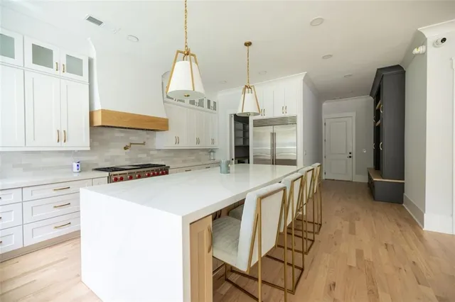 a kitchen with stainless steel appliances granite countertop a sink a stove and a wooden floors