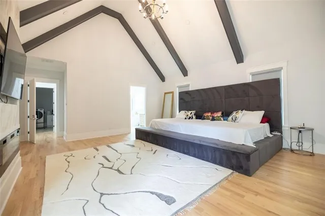 a spacious bedroom with a bed and mirror