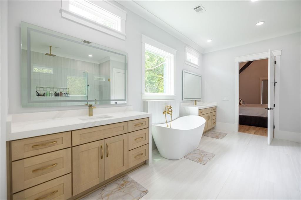 3470 Hamilton Mill Road Buford, GA 30519 - Photo 30 of 39 a spacious bathroom with a double vanity sink a mirror and a bathtub