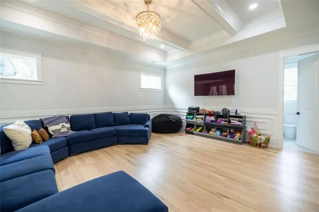 a living room with furniture a wooden floor and a ceiling fan