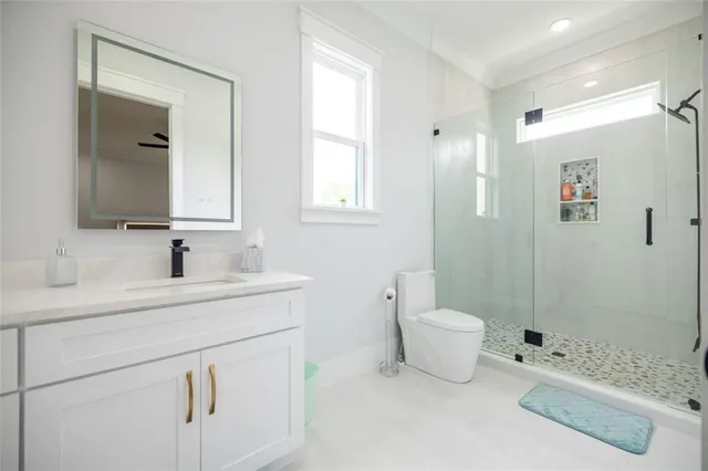 a bathroom with a sink a toilet and shower