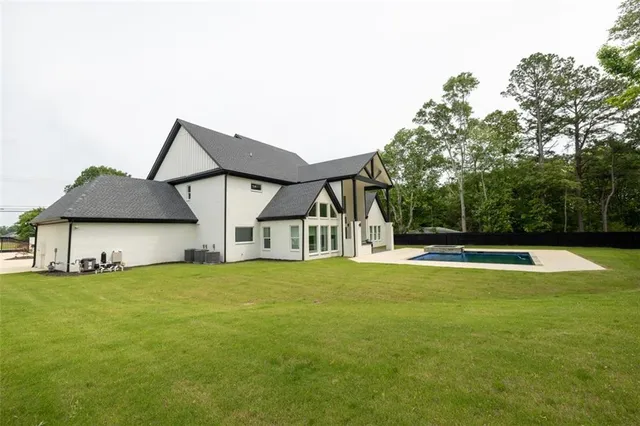 a view of a house with a big yard and large trees