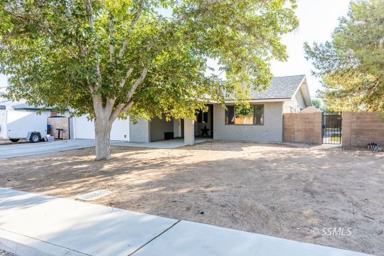 1116 South Allen Street Ridgecrest, CA 93555 - Photo 4 of 33 a view of a house with a tree and a yard