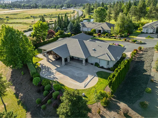 an aerial view of a house with a garden and lake view