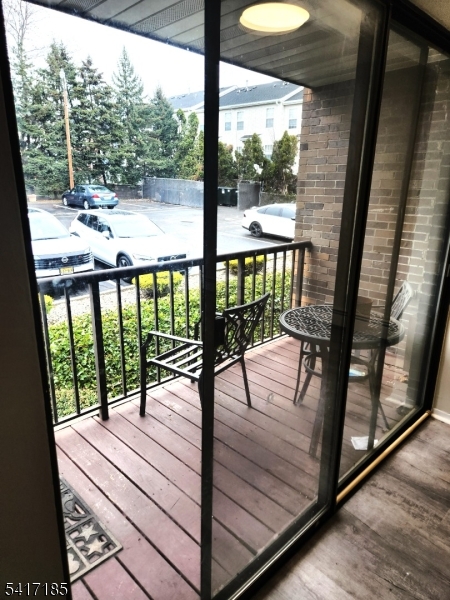365 River Road, Unit E Nutley, NJ 07110 - Photo 4 of 14 a view of a balcony with chair and wooden floor