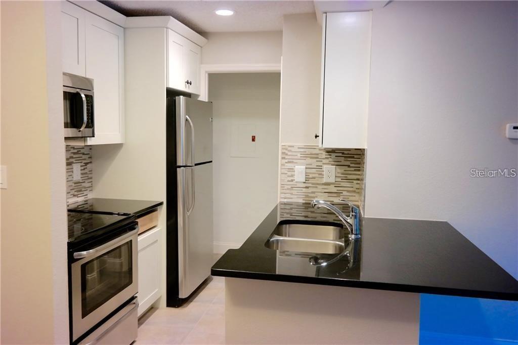 224 Afton Square, Unit 104 Altamonte Springs, FL 32714 - Photo 3 of 13 a kitchen with a refrigerator and a stove