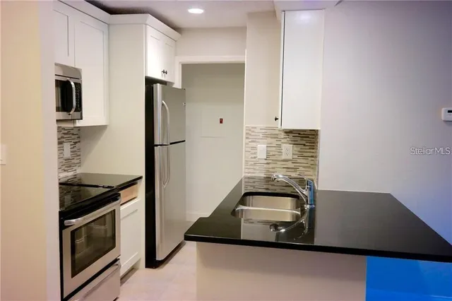 a kitchen with a refrigerator and a stove