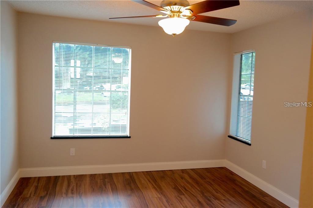 224 Afton Square, Unit 104 Altamonte Springs, FL 32714 - Photo 8 of 13 a view of an empty room with wooden floor and a window