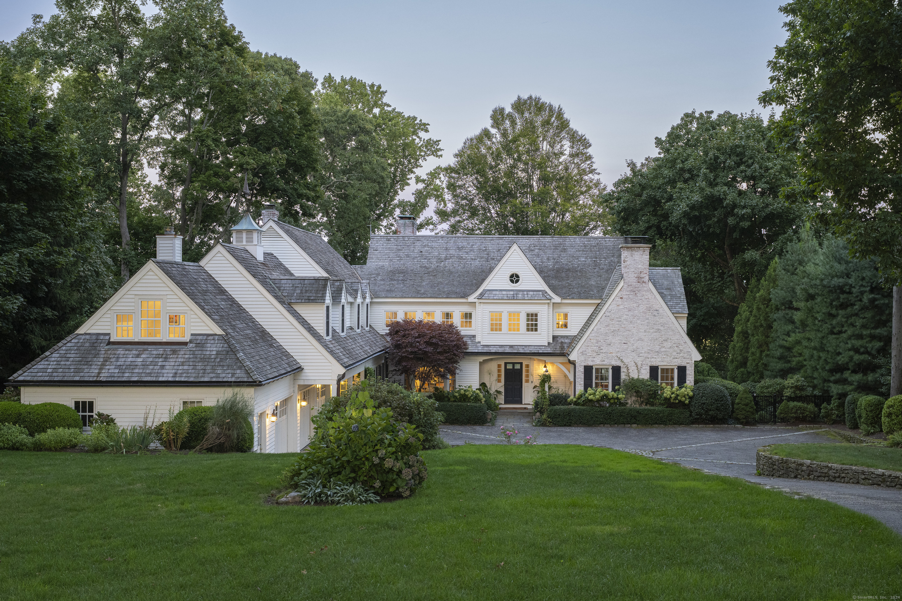 123 Long Neck Point Road Darien, CT 06820 - Photo 1 of 1 a front view of a house with a garden and trees