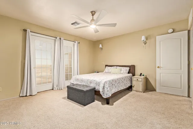 a spacious bedroom with a large bed and a chandelier