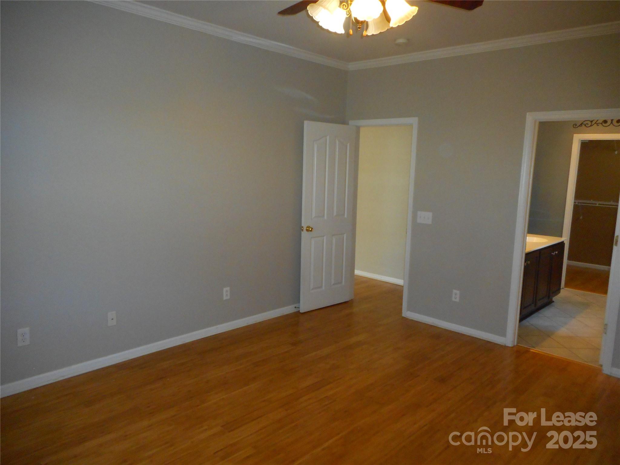 17207 Overstone Court Charlotte, NC 28277 - Photo 16 of 28 an empty room with wooden floor chandelier fan and windows