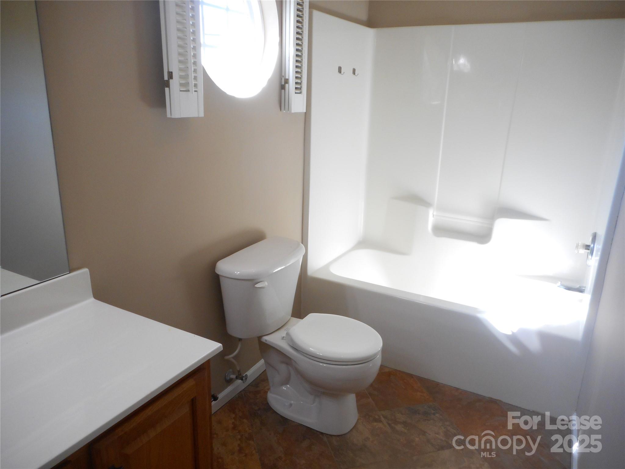 17207 Overstone Court Charlotte, NC 28277 - Photo 25 of 28 a white toilet sitting next to a bathroom sink and vanity