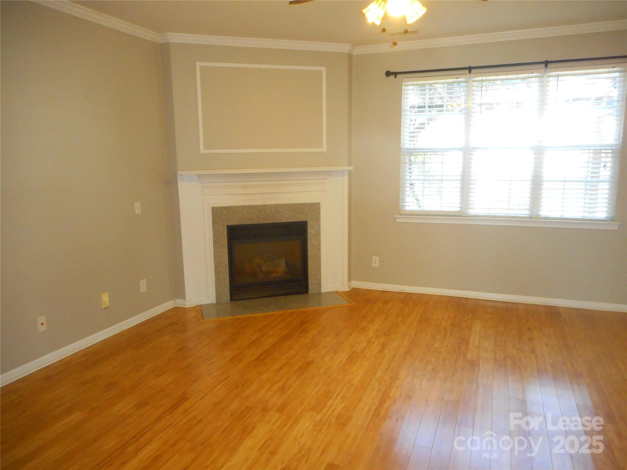 17207 Overstone Court Charlotte, NC 28277 - Photo 5 of 28 a view of an empty room with wooden floor fireplace and a window