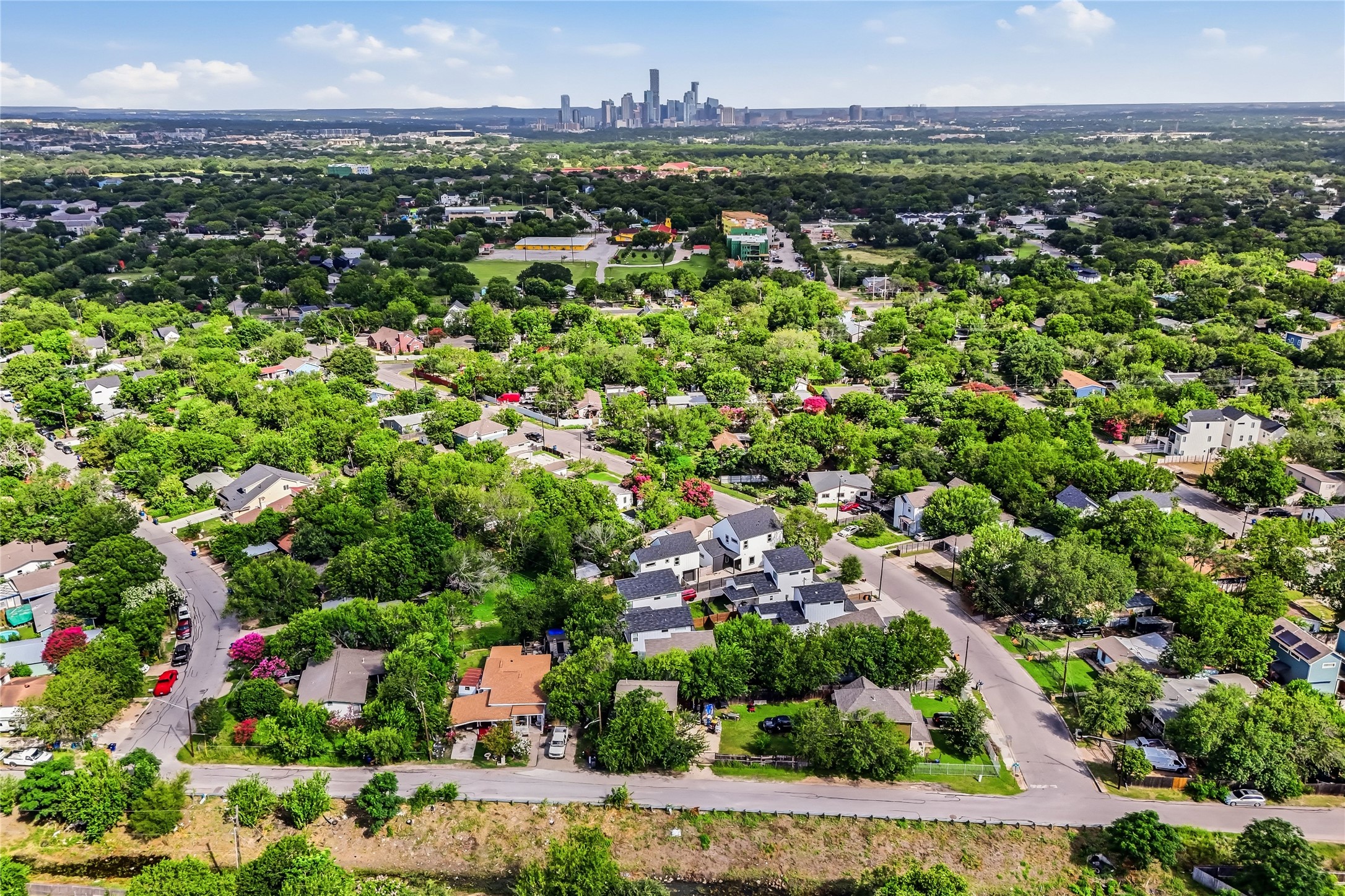 6809 Porter Street, Unit 1 Austin, TX 78741 - Photo 38 of 40 An aerial perspective reveals a verdant neighborhood with a distant cityscape of downtown ATX.