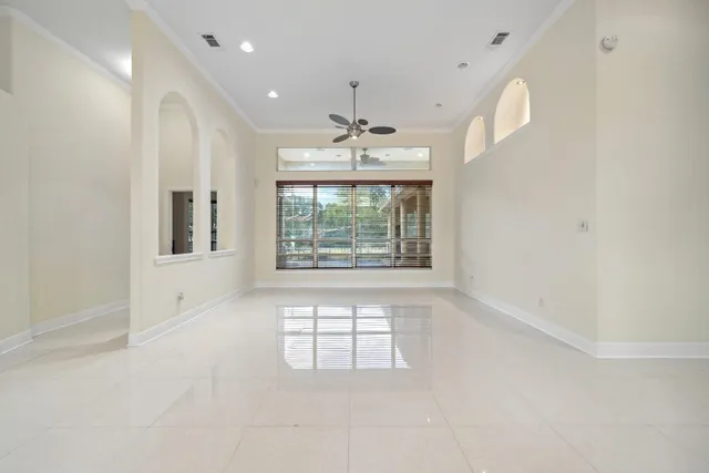 en empty room with windows and chandelier