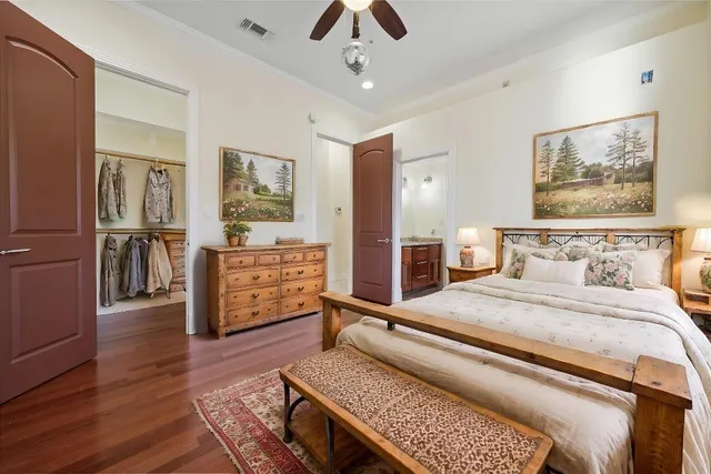 an empty room with wooden floor ceiling fan and windows