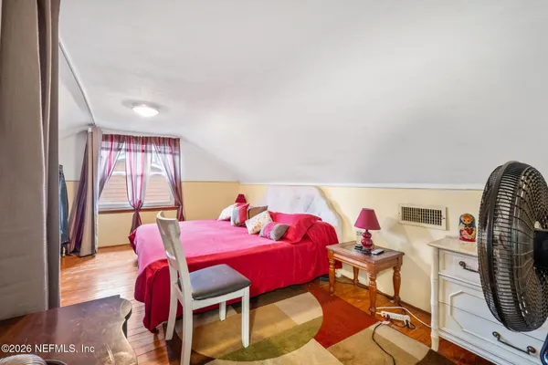 a living room with furniture a wooden floor and next to a window