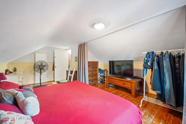 a bedroom with a bed and a flat screen tv
