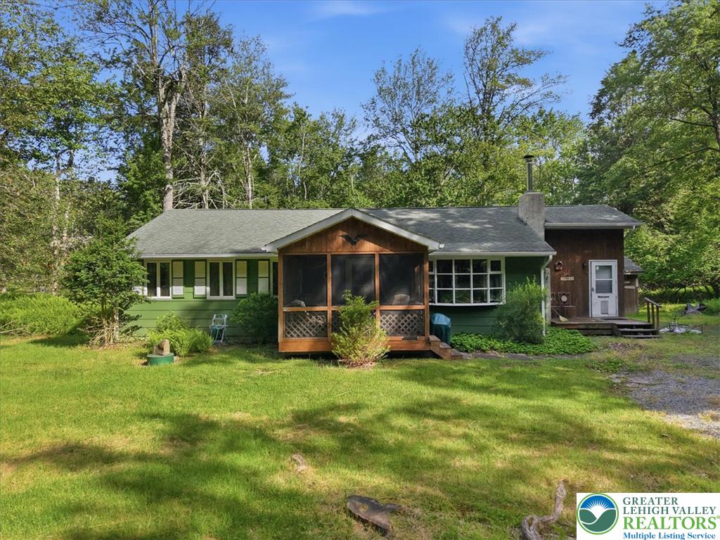A verdant retreat, this residence features a screened porch and mature trees for a private setting.