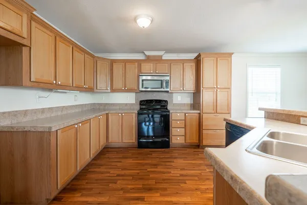 a kitchen with granite countertop a stove top oven sink and cabinets