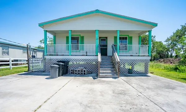 a view of a house with a patio and a yard