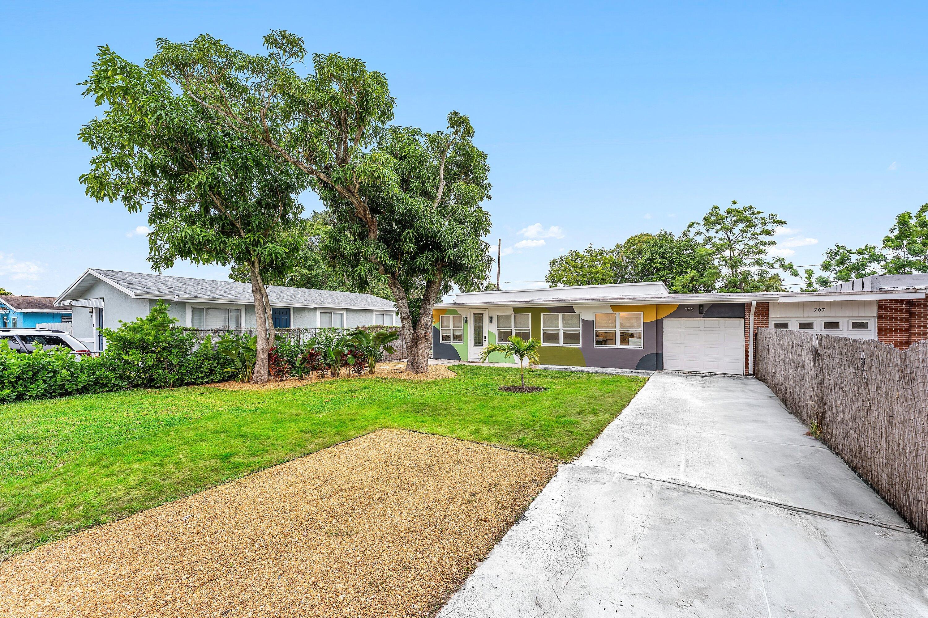 709 Southwest 9th Court Delray Beach, FL 33444 - Photo 2 of 32 a front view of a house with a yard and potted plants