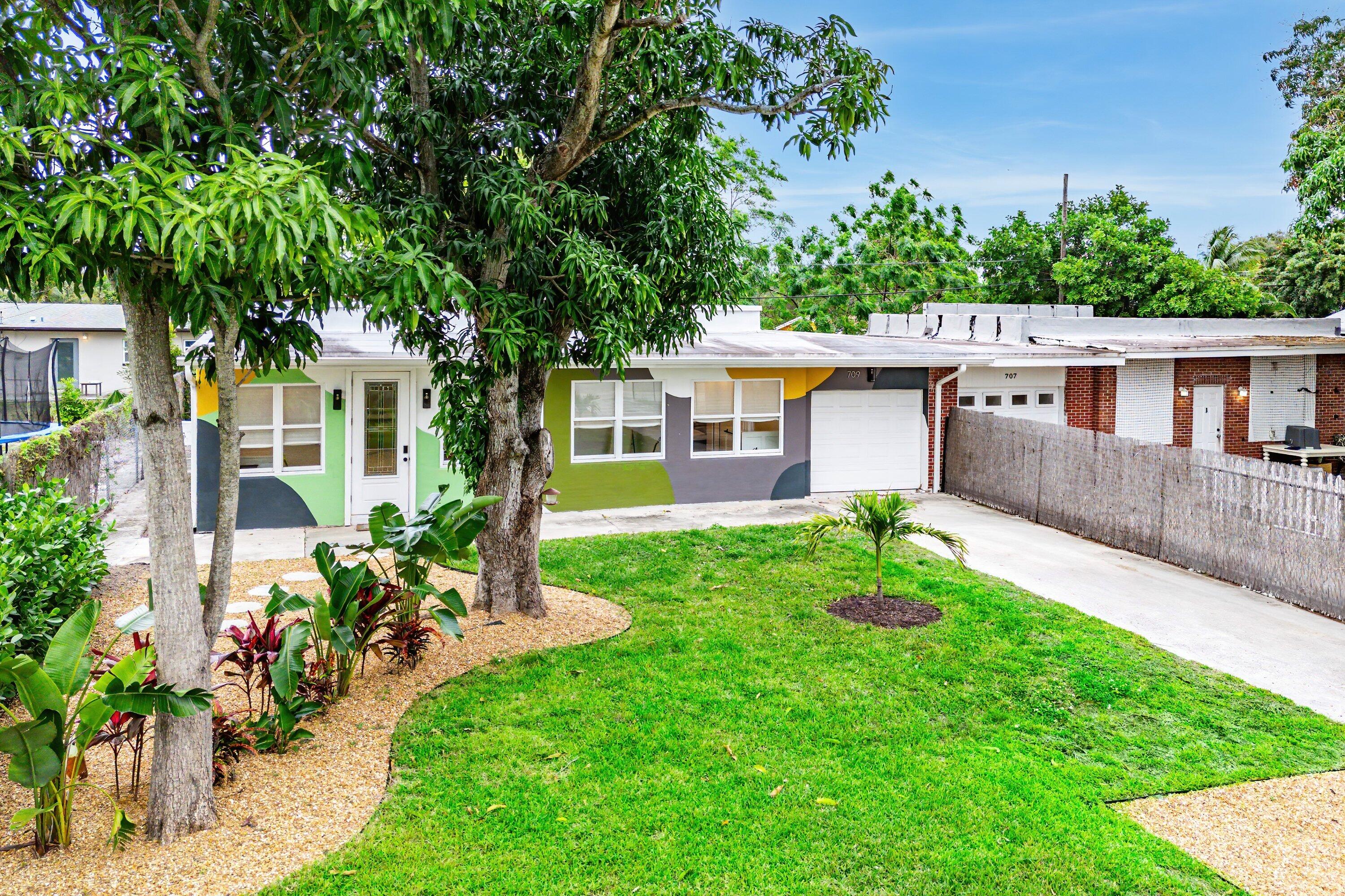 709 Southwest 9th Court Delray Beach, FL 33444 - Photo 29 of 32 a front view of a house with a yard and potted plants