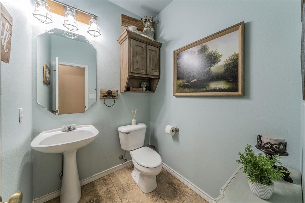 1992 Bledsoe Road Gunter, TX 75058 - Photo 15 of 40 a bathroom with a toilet a sink and mirror