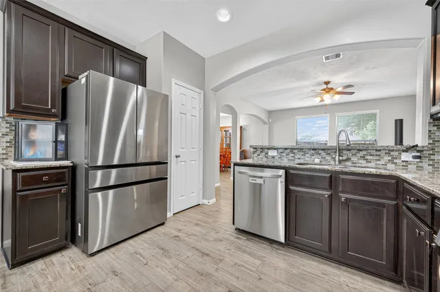 a kitchen with stainless steel appliances granite countertop a stove microwave and sink