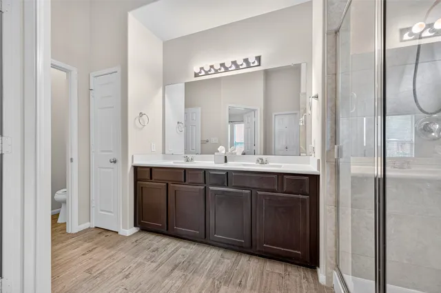 a bathroom with a glass shower door and a sink
