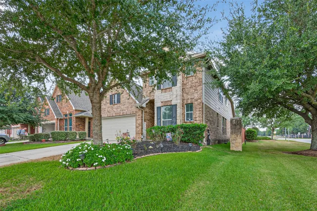 a front view of a house with a garden and tree